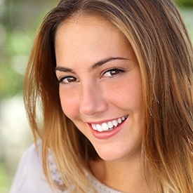 A woman smiling outside.