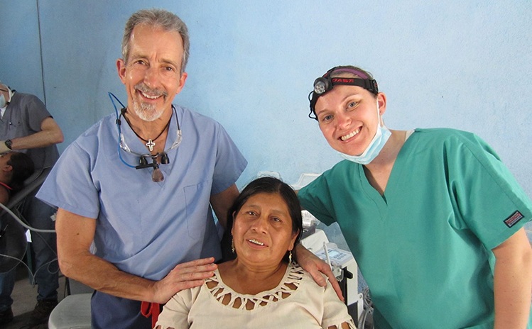 Dentist and team member smiling with patient