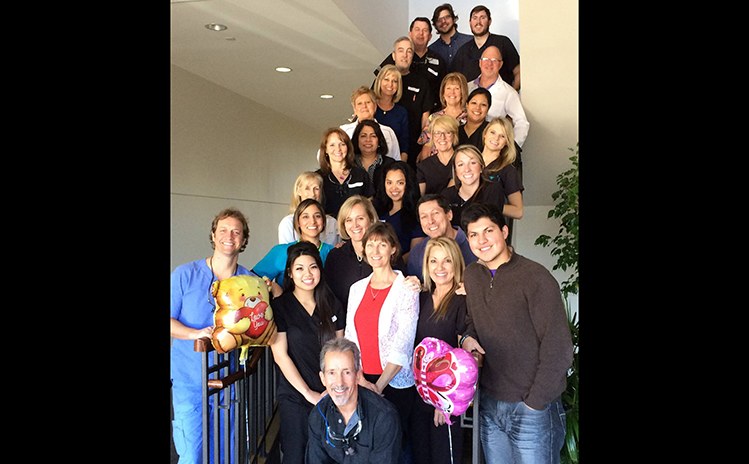 Large group of people posing together on stairs