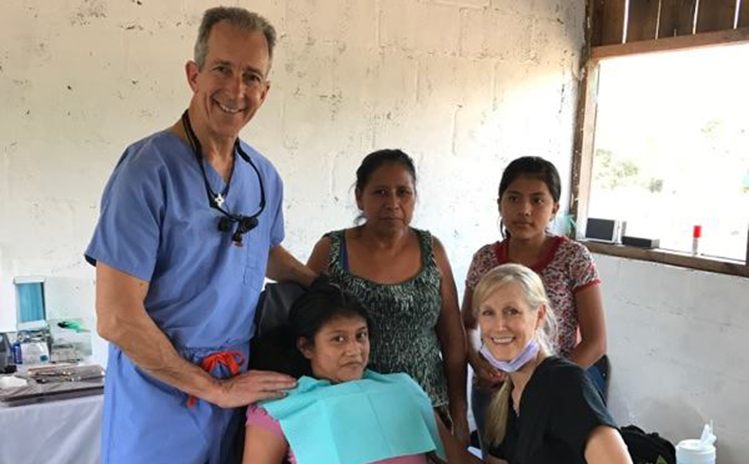 Dentist and volunteers posing with patient