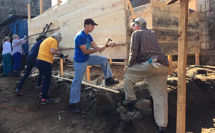 Dentist and volunteers building a structure