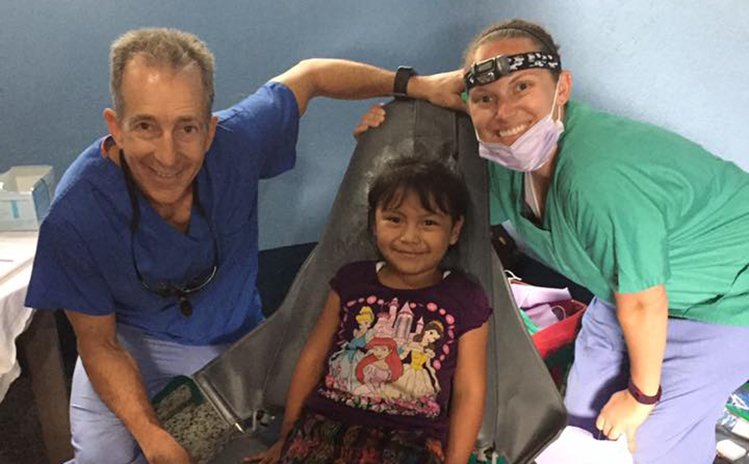 Dentist and assistant smiling with patient