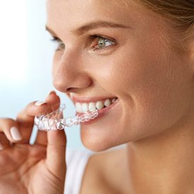 Woman placing Invisalign tray