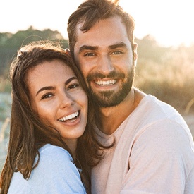 Couple smiling and hugging outside