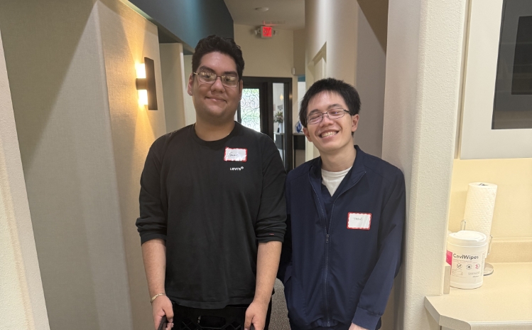 Dental team members standing at the front desk with dental care items