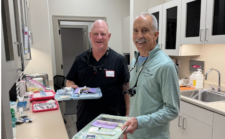 Dental team members posing with Chick-fil-A catering boxes during an event