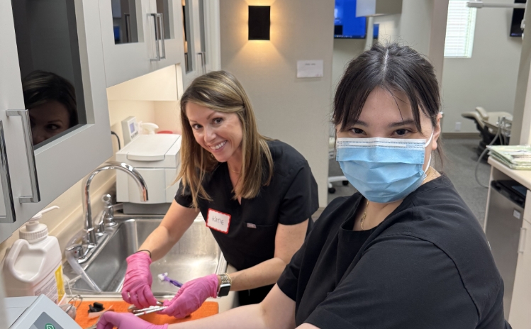 Dental professional posing with a patient in a dental treatment room