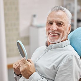 a patient smiling after receiving his dental implants