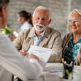 An elderly couple attending a dental implant consultation