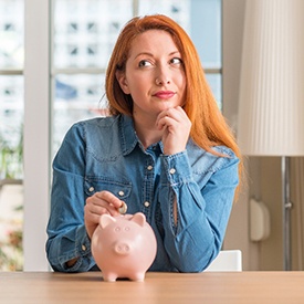 Woman putting coin in piggy bank