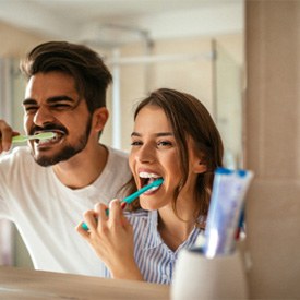 a couple brushing their teeth together