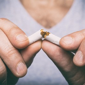 hands breaking a cigarette in half