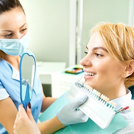 A dentist using a shade guide to determine the correct color for a patient’s dental filling in Mesquite