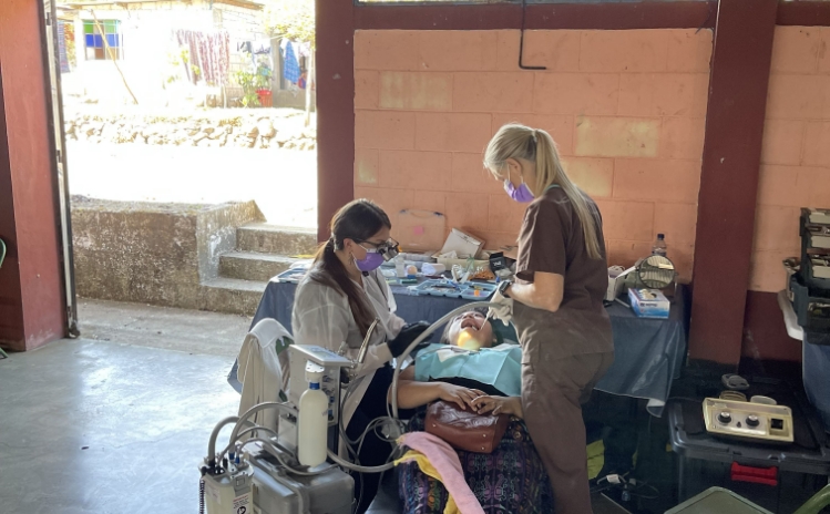 Dental professional treating a young patient in a portable clinic chair