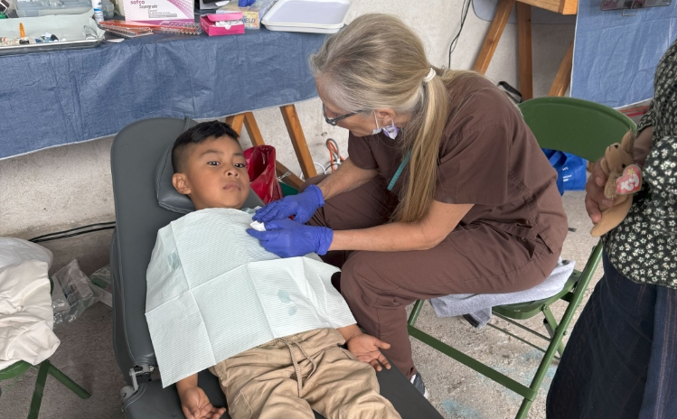 Dentist and assistant treating a patient in a temporary dental setup
