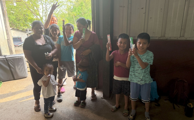 Group of children sitting together outside during a community outreach event