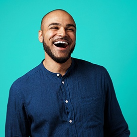 smiling man on teal background 