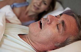 Man snoring in bed