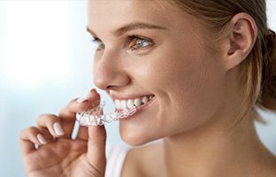 Woman placing Invisalign tray