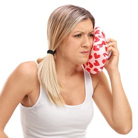 woman applying cold compress to face