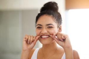 Woman flossing her teeth