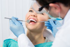 woman smiling receiving dental checkup