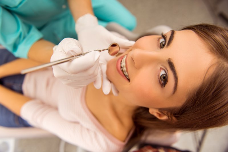 Teen with braces smiling at dental appointment