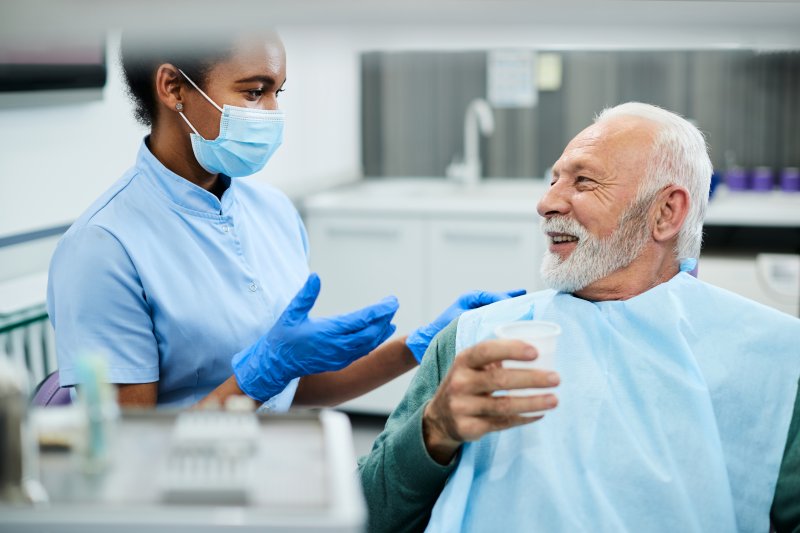 dentist explaining difference between partial dentures and dental bridges in Mesquite